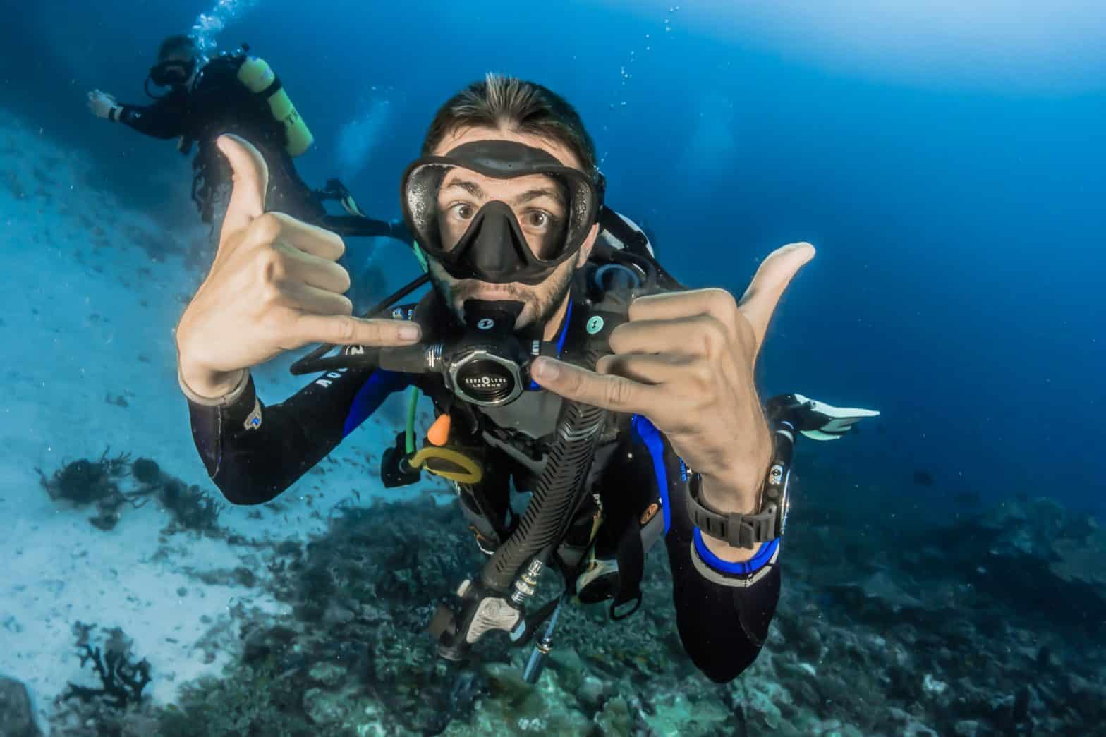 a scuba driver making cool hand gesture