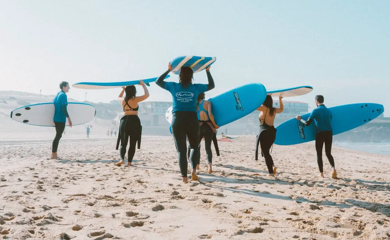 group of surfers carrying surf boards