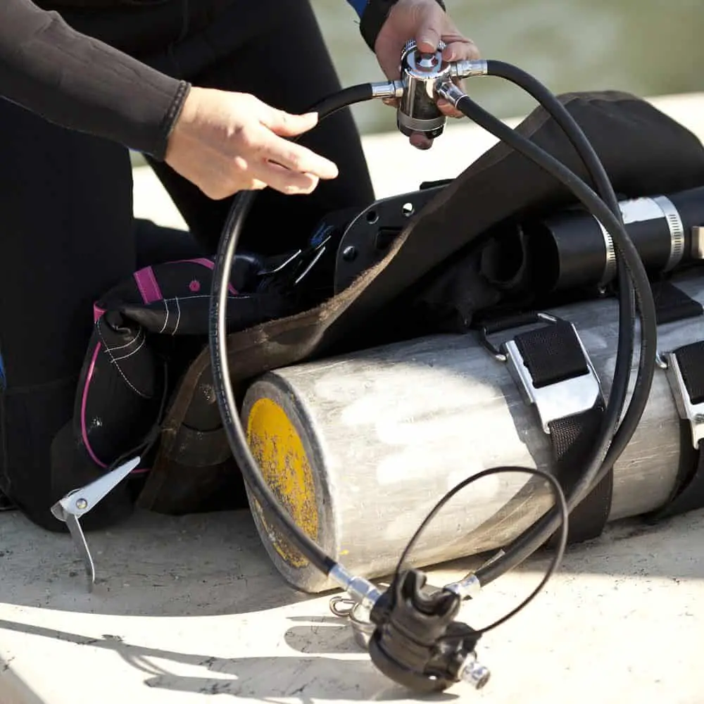 person assembling scuba gear