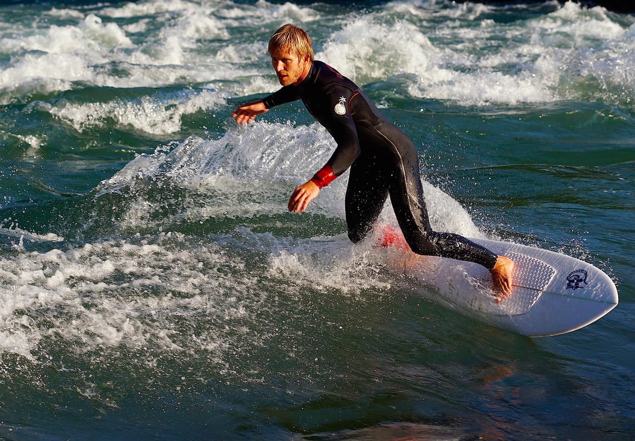 man on wetsuit surfing