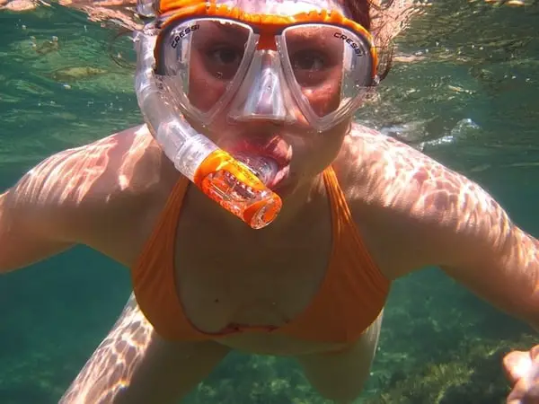 girl in an orange swimsuit under the sea