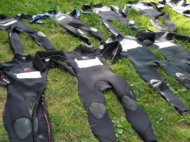 several wetsuits lying on lawn